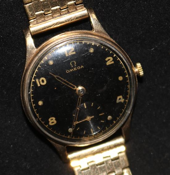 A gentlemans 1940s 9ct gold Omega wrist manual wind watch, with black Arabic dial on rolled gold bracelet.